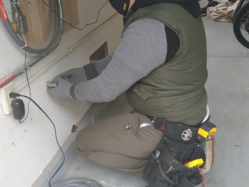 Electrician performing outlet wiring in a Evesham garage